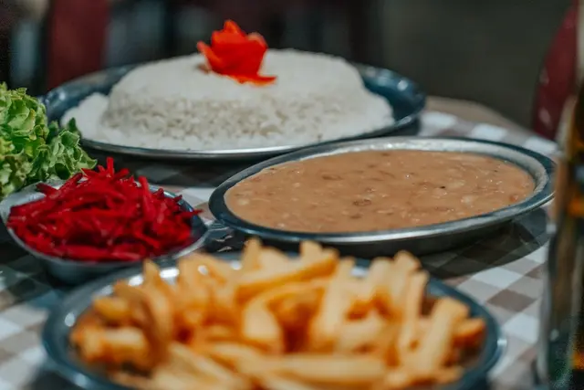 Arroz, feijão e batata frita do almoço caseiro no restaurante da pousada