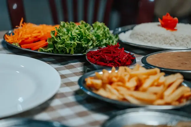 Saladas frescas, arroz, feijão e batata frita servidos no restaurante da pousada