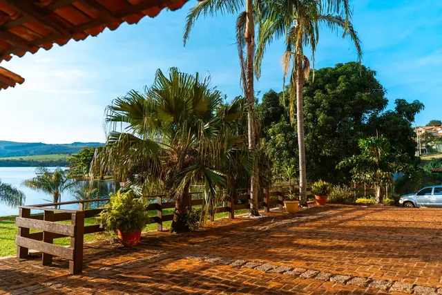 Deck de pedra com palmeiras e vista para o Lago de Furnas na Pousada Solar Dona Dora em Capitólio