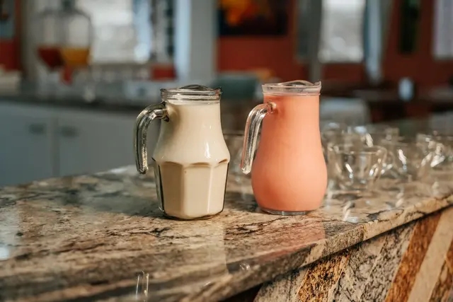 Jarras de leite e vitamina de morango servidas no café da manhã