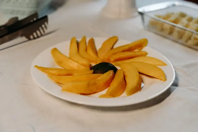 Prato de manga fresca fatiada servido no café da manhã da pousada