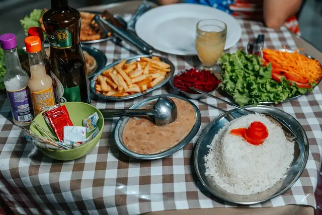 Mesa posta com almoço mineiro completo: arroz, feijão, batata frita e saladas