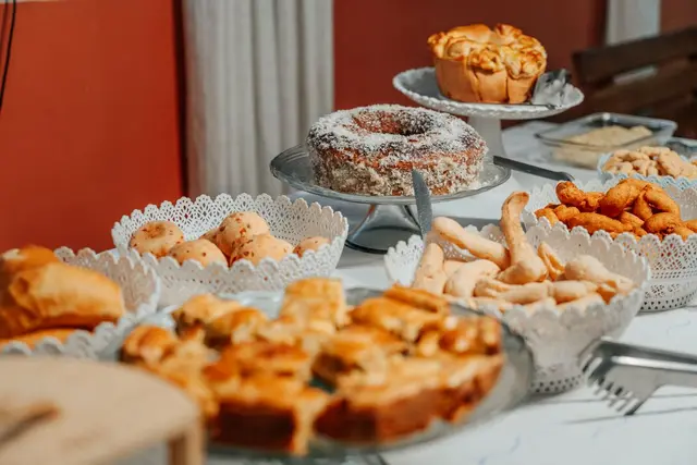 Mesa farta de café da manhã com bolos, salgados e quitandas caseiras mineiras