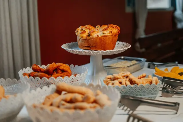 Mesa de café da manhã com pães, roscas e quitandas caseiras da Pousada Solar Dona Dora