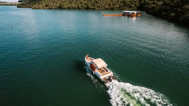 Passeio de lancha no Lago de Furnas com deck flutuante ao fundo em dia de sol