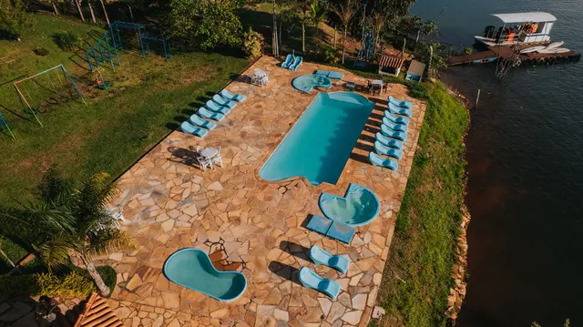Vista aérea da piscina com toboáguas, espreguiçadeiras e parquinho da Pousada Solar Dona Dora