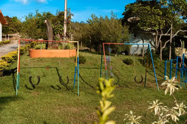 Playground com balanços de pneu no jardim gramado da Pousada Solar Dona Dora