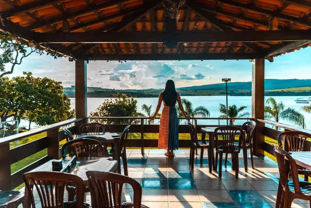 Varanda do restaurante com mesas e vista panorâmica do Lago de Furnas na Pousada Solar Dona Dora