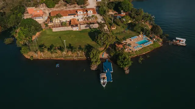 Vista aérea da Pousada Solar Dona Dora com piscina, campo de futebol e píer no Lago de Furnas